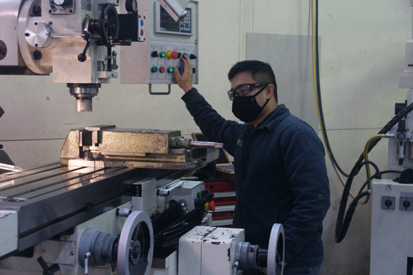 An image of a man wearing a mask, machining components