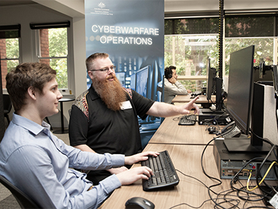 Mr Tim Pitts (DSTG) chats to IW Scholarship student Ethan Selway (University of Adelaide). 