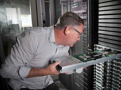 HPC team member Chris Howlett inspects one of the HPC pilot racks.