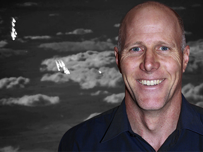 A VIRSuite generated scene for air-to-air missile testing with an aircraft dispensing flares in front of a cloud background. Shawn Garner, pictured inset.