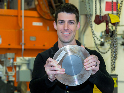 Shannon Ryan is holding one of the twelve ceramic samples tested at the Oak Ridge National Laboratory's beam line for residual stress.