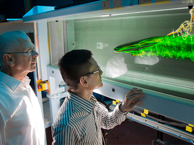 Picture of DST Honorary Fellow Dr Lincoln Erm and Dr Soon-Kong Lee observing a generic australian navy submarine's model's wake. 