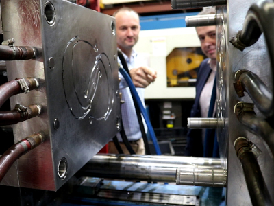 Jim Grose (left), Managing Director of Axiom, and Ben Barona, from DST, examining the injection moulding die being used to produce face shield headbands.