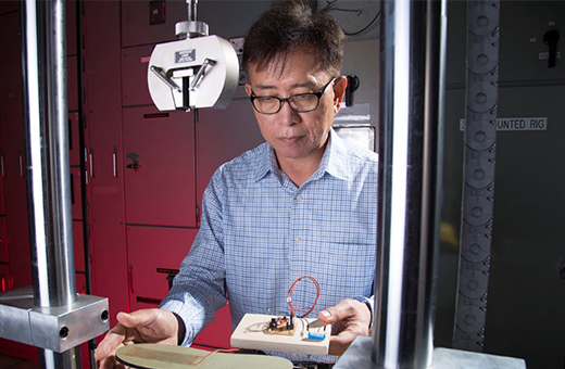 Chang Ho Choi testing modified boot soles that generate electricity when flexed during walking.