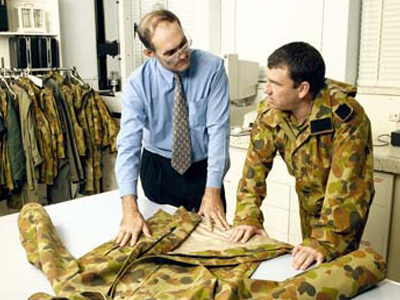 Graeme Egglestone (left) inspects a camouflage jacket with a soldier.