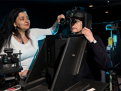 Maria Gavrilescu and Peter Gibbs prepare to conduct an experiment on visual performance with a night vision device used in Army aviation.