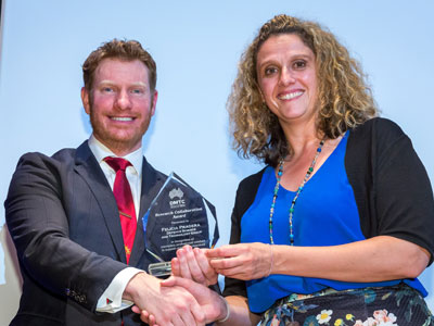 Corporal Daniel Keighran VC presenting DST's Felicia Pradera with the DMTC Research Collaboration Award. Image courtesy of DMTC Ltd. A photograph of Corporal Daniel Keighran VC and DST's Felicia Pradera