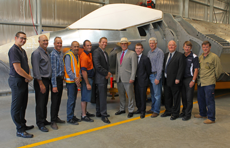 Minister Snowdon poses with DSTO personnel in front of the Iron Bird. A photograph of the Minister for Defence Science and Personnel standing with DSTO personnel in front of the model of the Joint Strike Fighter.
