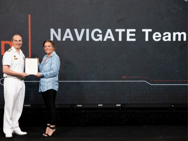 Team NAVIGATE representative Jessica Brophy receives her team’s 2024 VCDF Award from Vice Admiral David Johnston, AC, RAN.