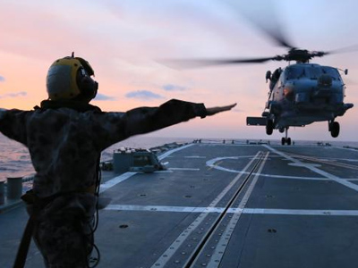 Image of a soldier signalling to a helicopter.