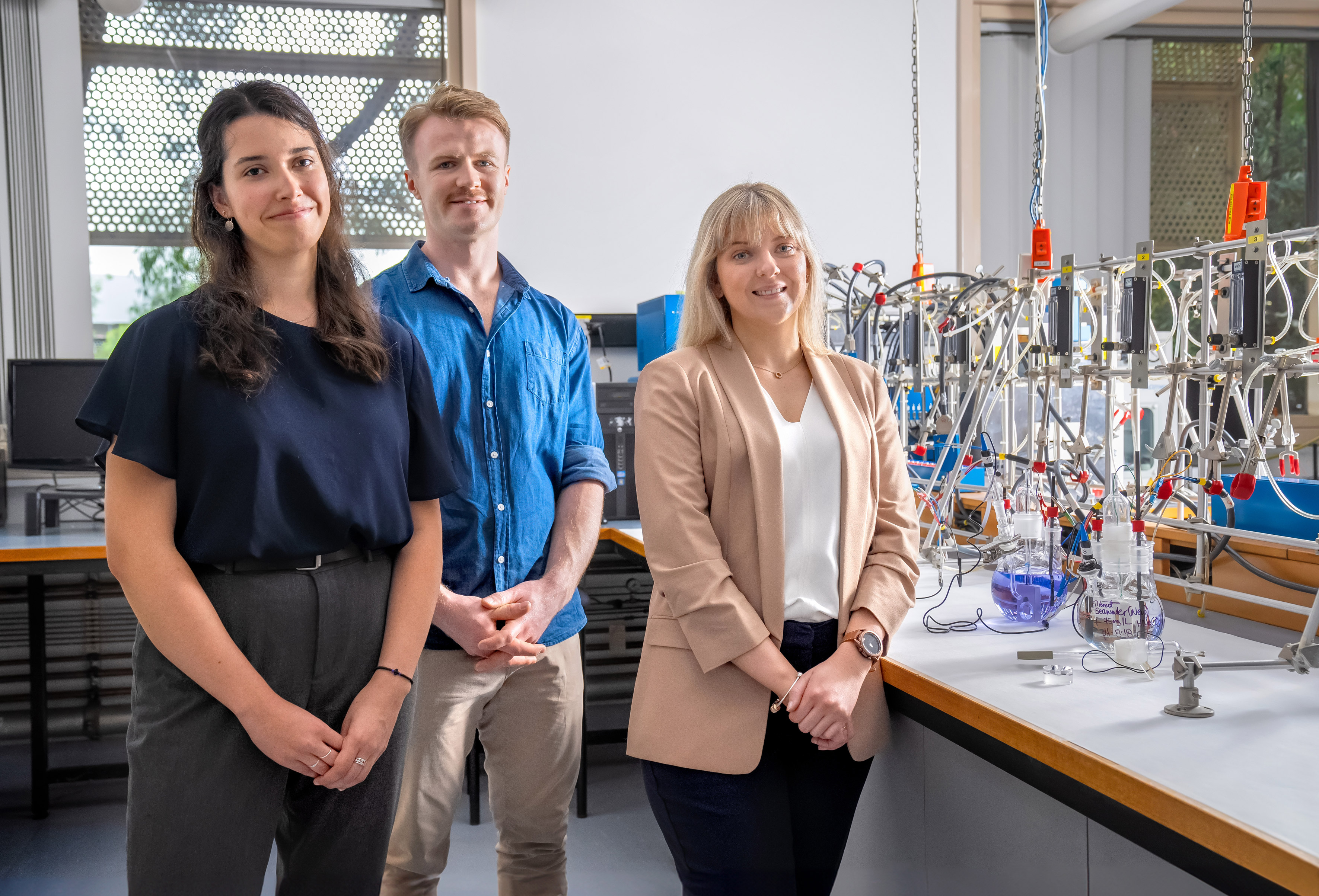 A group of young scientists standing in front of a lab table