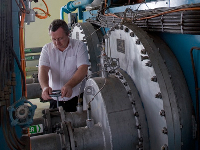 An image of a man working on a compressor in the Combustion Test Facility