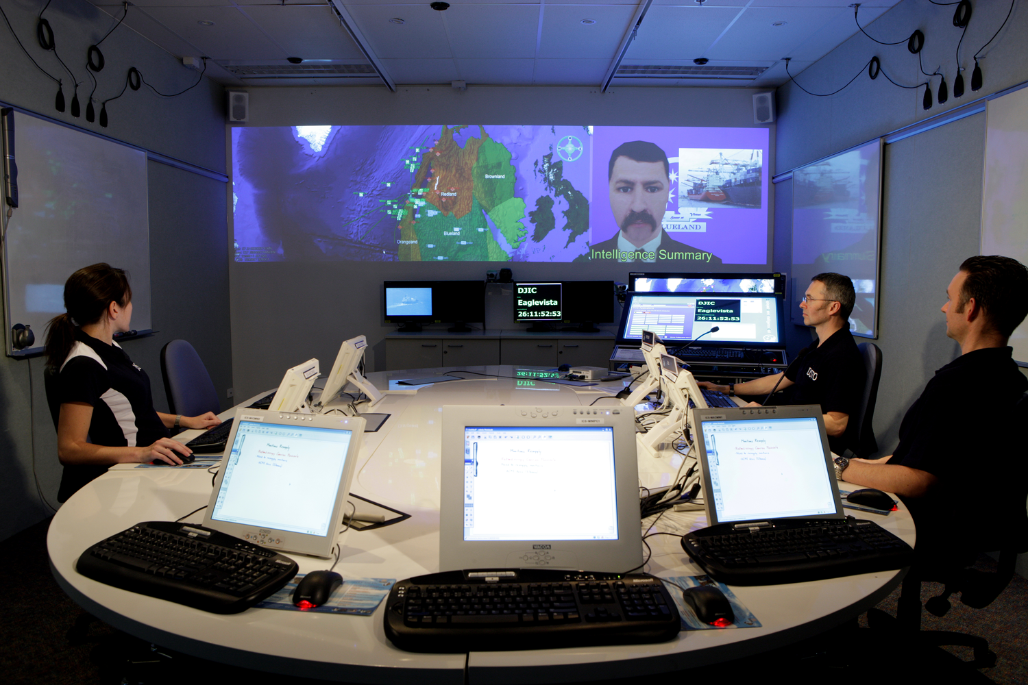 DSTO's Intense Collaboration Space laboratory is controlled by the DSTO-developed and now open-sources Livespaces Operating System for distributed collaboration within smart meeting room environments. On the projected screens a Virtual Adviser (right) is briefing meeting participants on a military scenario with the aid of a Virtual Battlespace (left). The Virtual Adviser and Virtual Battlespace software were also developed by DSTO.