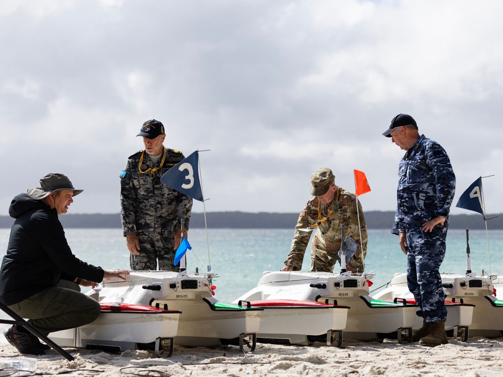 A Defence scientist and ADF members work together on uncrewed systems during the Technical Cooperation Program AI Strategic Challenge 2023 at HMAS Creswell, Jervis Bay Territory.