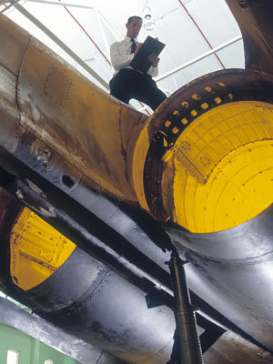 A photograph of a scientist assessing an F-111 airframe.