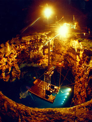 A photograph of barra sonobuoy being tested at night, under lights in a large hole.