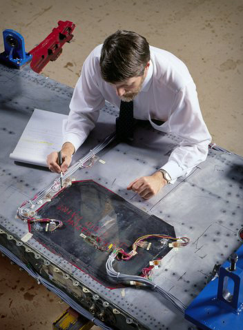 Dr. Richard Chester examines a composite bonded repair to an F-111 wing.