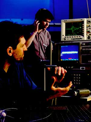 A Defence scientist demonstrating how sound waves are received through the fibre-optic cable (hydrophone).