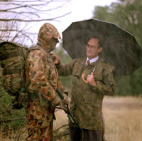 Graeme Eggleston assess raingear A photo of Graeme Eggleston assessing raingear on a soldier in the rain