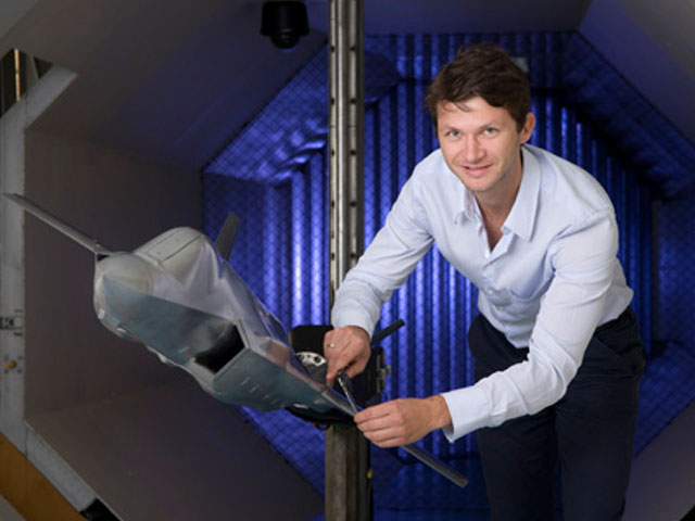 DST scientist in the Low Speed Wind Tunnel with a model plane.