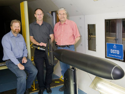 Three scientists with a submarine model in DST's Low Speed Wind Tunnel. Three scientists with a submarine model in DST's Low Speed Wind Tunnel.