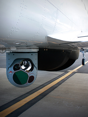 An aircraft with surveillance cameras mounted below it.