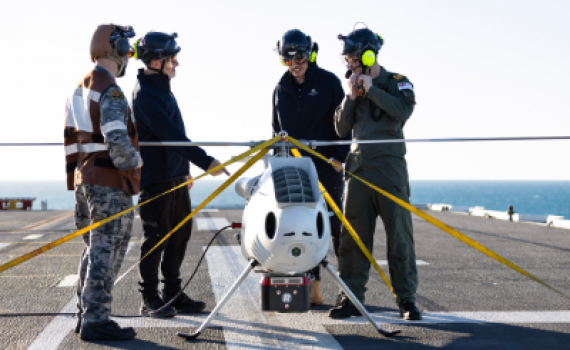 S100 Crew from 822X Squadron and scientists from Defence Science and Technology Group discuss the S100 Bathymetric LiDAR Sensor trials on the Flight Deck of HMAS Adelaide during Exercise Sea Raider 23.