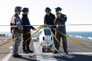 S100 Crew from 822X Squadron and scientists from Defence Science and Technology Group discuss the S100 Bathymetric LiDAR Sensor trials on the Flight Deck of HMAS Adelaide during Exercise Sea Raider 23.