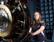 A photograph of a DST Group researcher checking Servo valve voltages on the Flight Motion Simulator as part of the pre-trial checks before a Hardware-in-the-Loop simulated flight engagement.