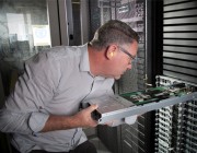 HPC team member Chris Howlett inspects one of the HPC pilot racks. HPC team member Chris Howlett inspects one of the HPC pilot racks.