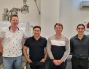 Scientists in a laboratory and smiling at camera