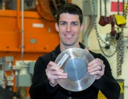 Shannon Ryan is holding one of the twelve ceramic samples tested at the Oak Ridge National Laboratory's beam line for residual stress.