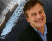 Dr Alex Zelinsky in front of a large photograph of a submarine.