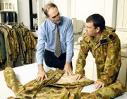 Graeme Egglestone (left) inspects a camouflage jacket with a soldier.