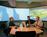 An image of three men at the Concept Exploration and Analysis Laboratory CEAL at DST Group in Sydney, discussing naval technology