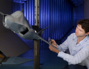 Photo of a staff member working on a model of the JSF aircraft in the Transonic Wind Tunnel.  