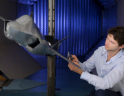 A model of the Joint Strike Fighter in the Transonic Wind Tunnel. The model was built by our Research Engineering team. Photo of a staff member working on a model of the JSF aircraft in the Transonic Wind Tunnel.