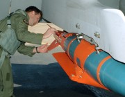 A pilot inspects a glide bomb. An image of a pilot inspecting a glide bomb.