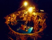 A photograph of barra sonobuoy being tested at night, under lights in a large hole.