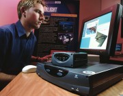 Photograph of a man seated at a computer with the Starlight box beside him.