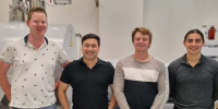 Scientists in a laboratory and smiling at camera