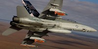 A Royal Australian Air Force F/A-18 Hornet in flight with two JDAM-ER 500lb bombs and two Time Space Position Information pods.