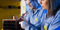 Scientists Alex McDonald and Franke Agenbag working on the Buccaneer CubeSat.