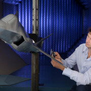Photo of a staff member working on a model of the JSF aircraft in the Transonic Wind Tunnel.  